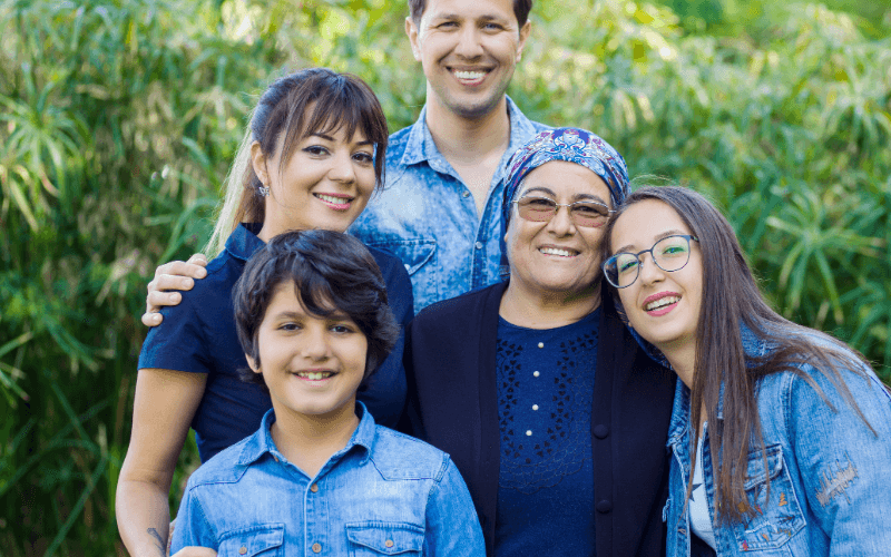 Aile bağlarını vurgulayan samimi bir fotoğraf, gülümseyen yüzler ve doğal bir arka plan