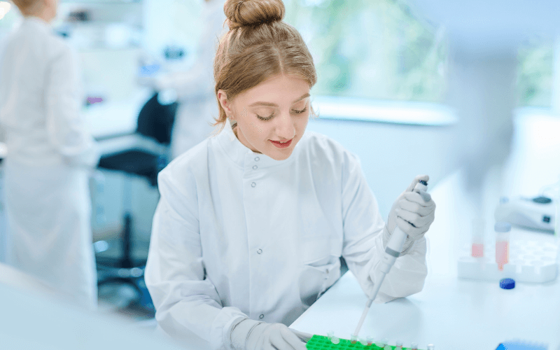 Laboratuvar ortamında çalışan bilim insanı deney yapıyor ve pipet kullanıyor
